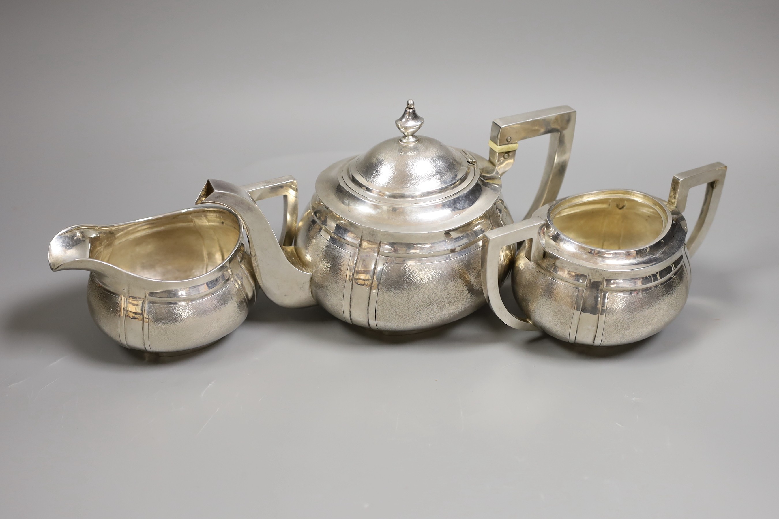 An early 20th century Chinese Export white metal three piece tea set, by Hung Chong?, with bone insulators, gross weight 33oz.